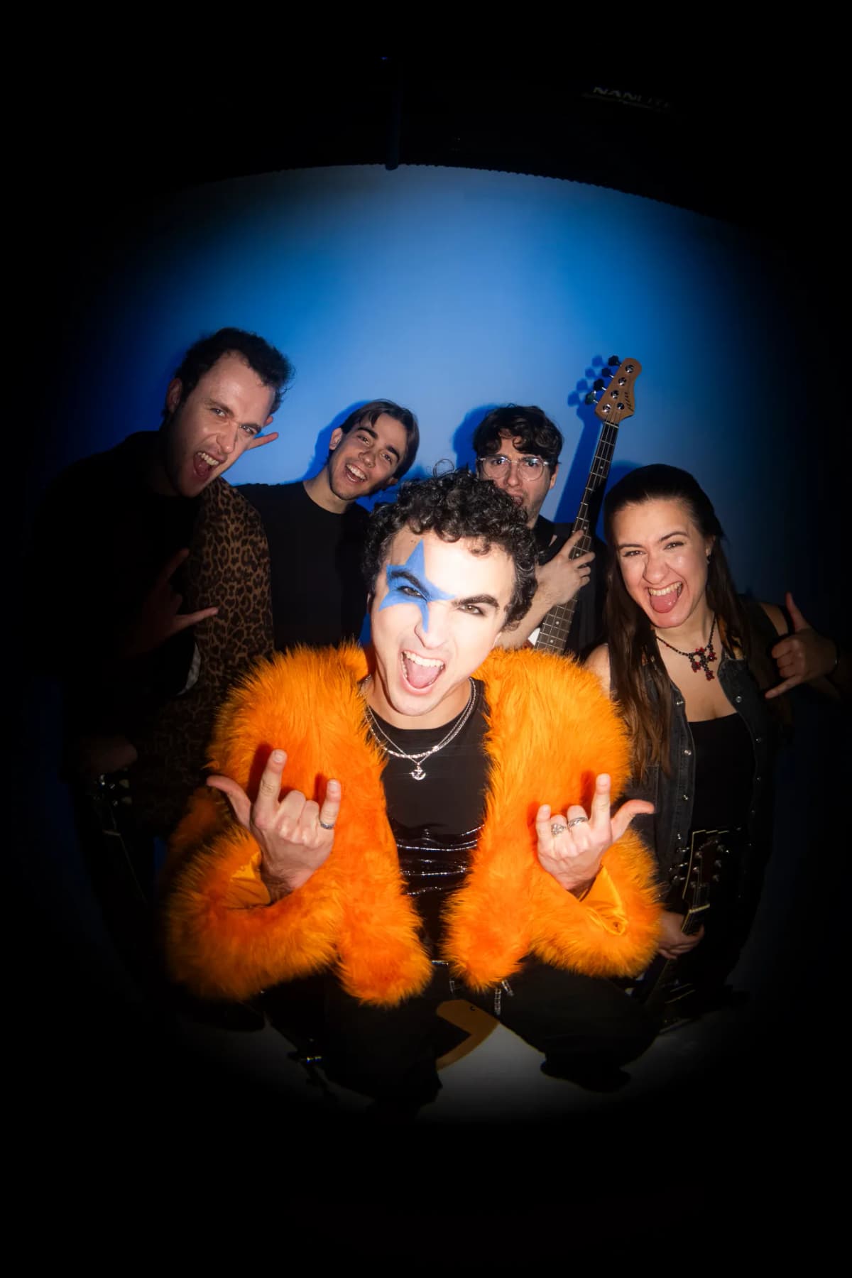 COSMÓ and band throwing rock signs, fisheye close-up